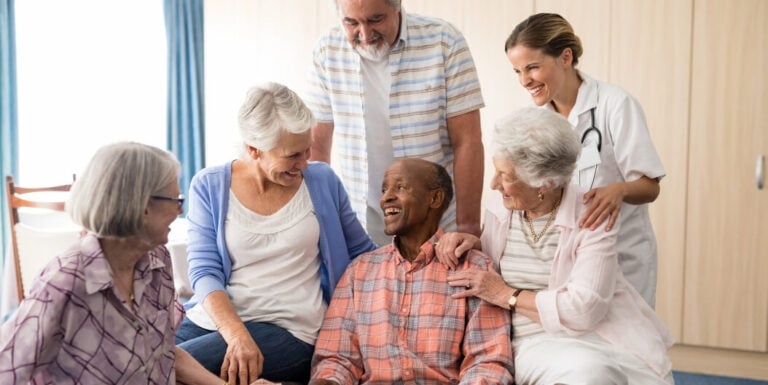 Elderly Residents Gathering with Female Nurse at Memory Care Facility